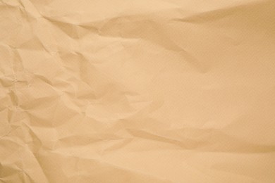 Photo of Texture of brown crumpled paper as background, closeup