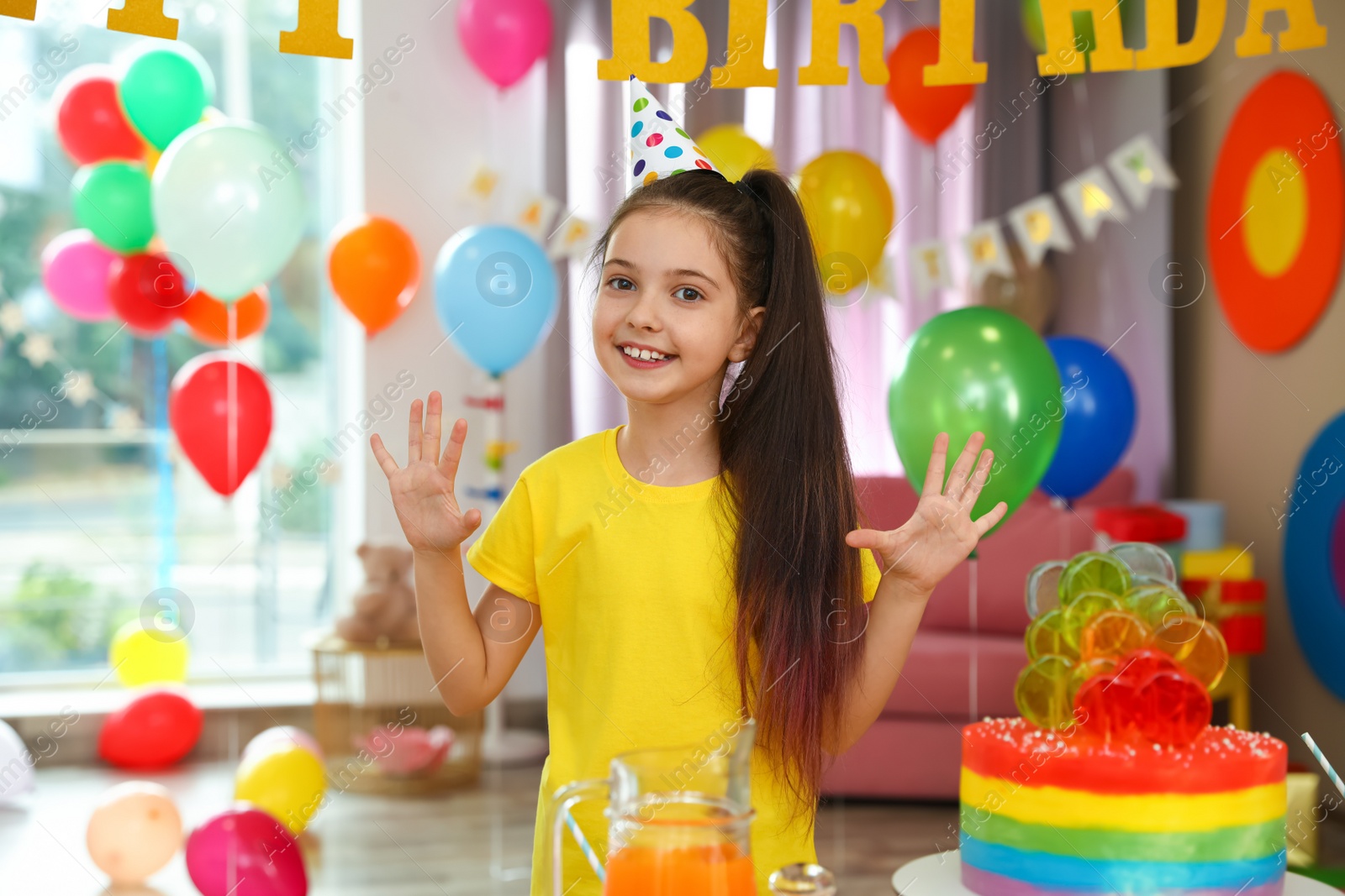 Photo of Happy girl in room decorated for birthday party