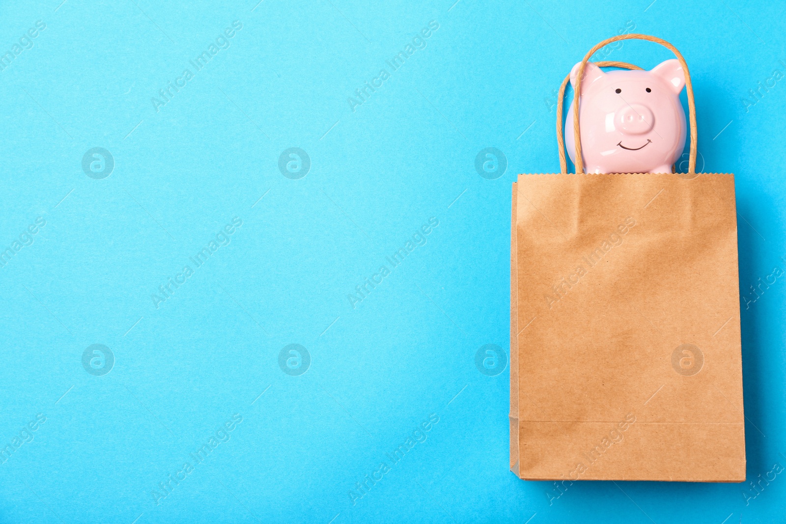 Photo of Flat lay composition with shopping bag and piggy bank on color background