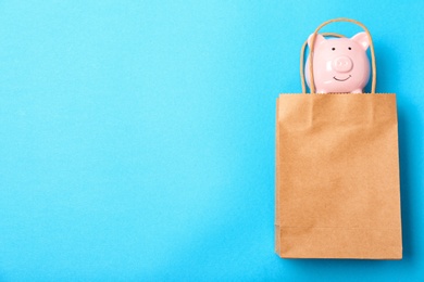 Flat lay composition with shopping bag and piggy bank on color background