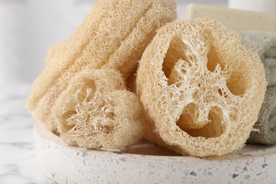 Photo of Natural loofah sponges on table, closeup view