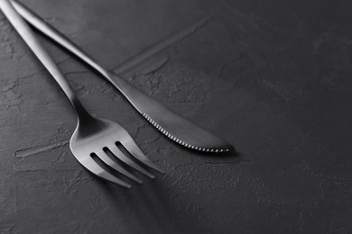 Photo of Beautiful cutlery set on black table, closeup