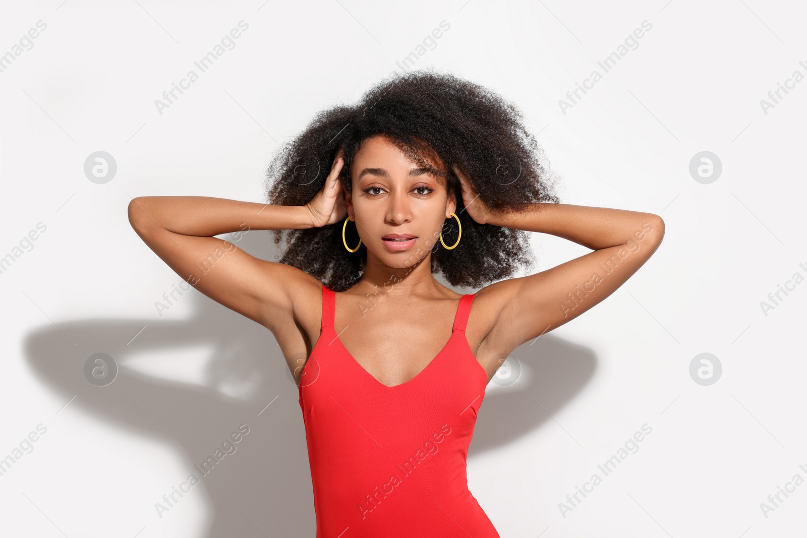 Photo of Beautiful woman in red one-piece summer swimsuit on white background