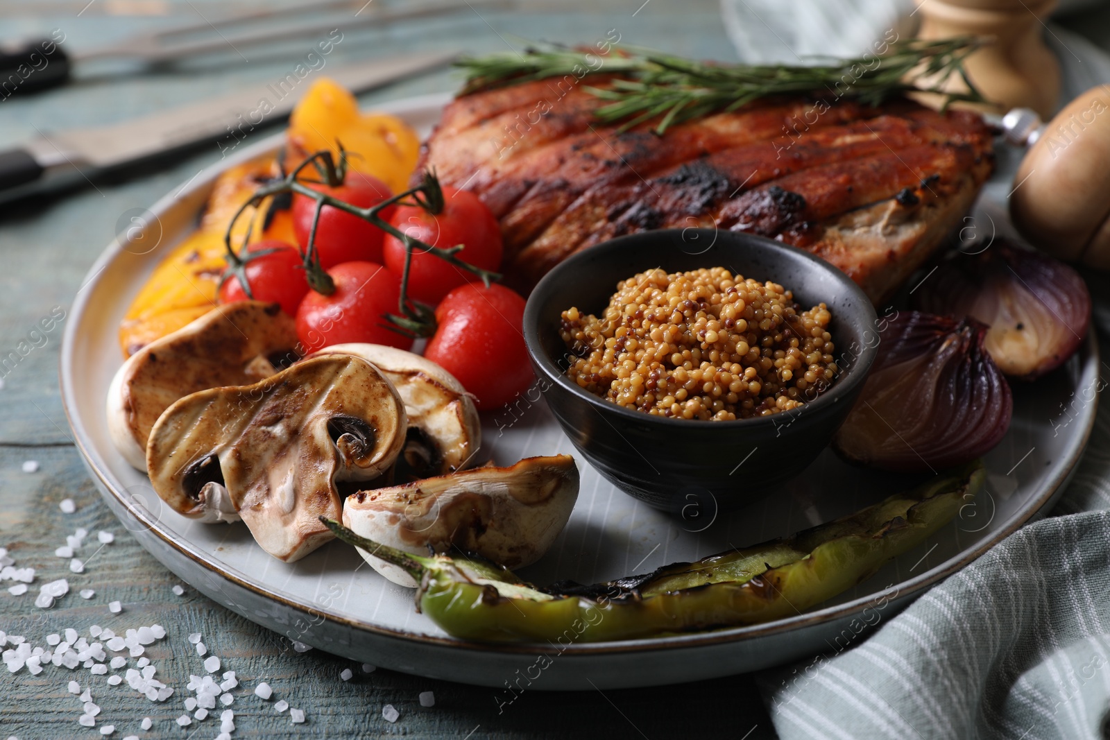 Photo of Delicious grilled meat and vegetables served on wooden table, closeup