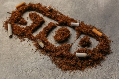 Photo of Word Stop made of tobacco and burnt cigarettes on grey textured table, closeup. No smoking concept