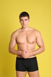 Photo of Man with sexy body on yellow background