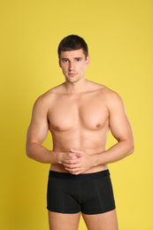 Man with sexy body on yellow background