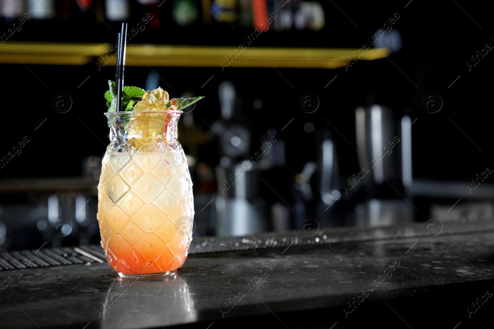 Photo of Fresh alcoholic Tequila Sunrise cocktail on bar counter. Space for text