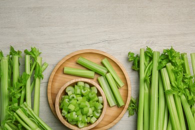 Photo of Many fresh cut celery stalks and leaves on wooden table, flat lay. Space for text
