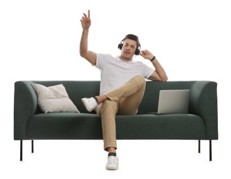 Photo of Man with laptop listening to music on comfortable green sofa against white background