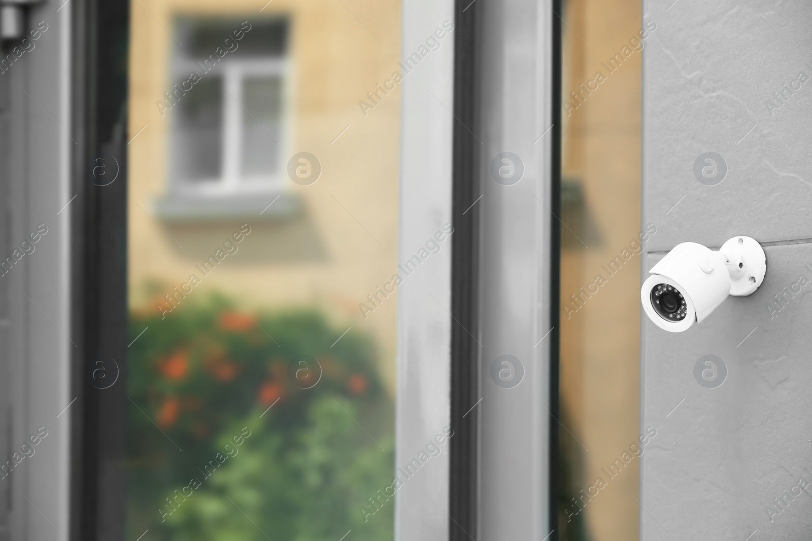 Photo of Modern security CCTV camera on wall outdoors