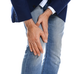 Man suffering from knee pain on white background, closeup