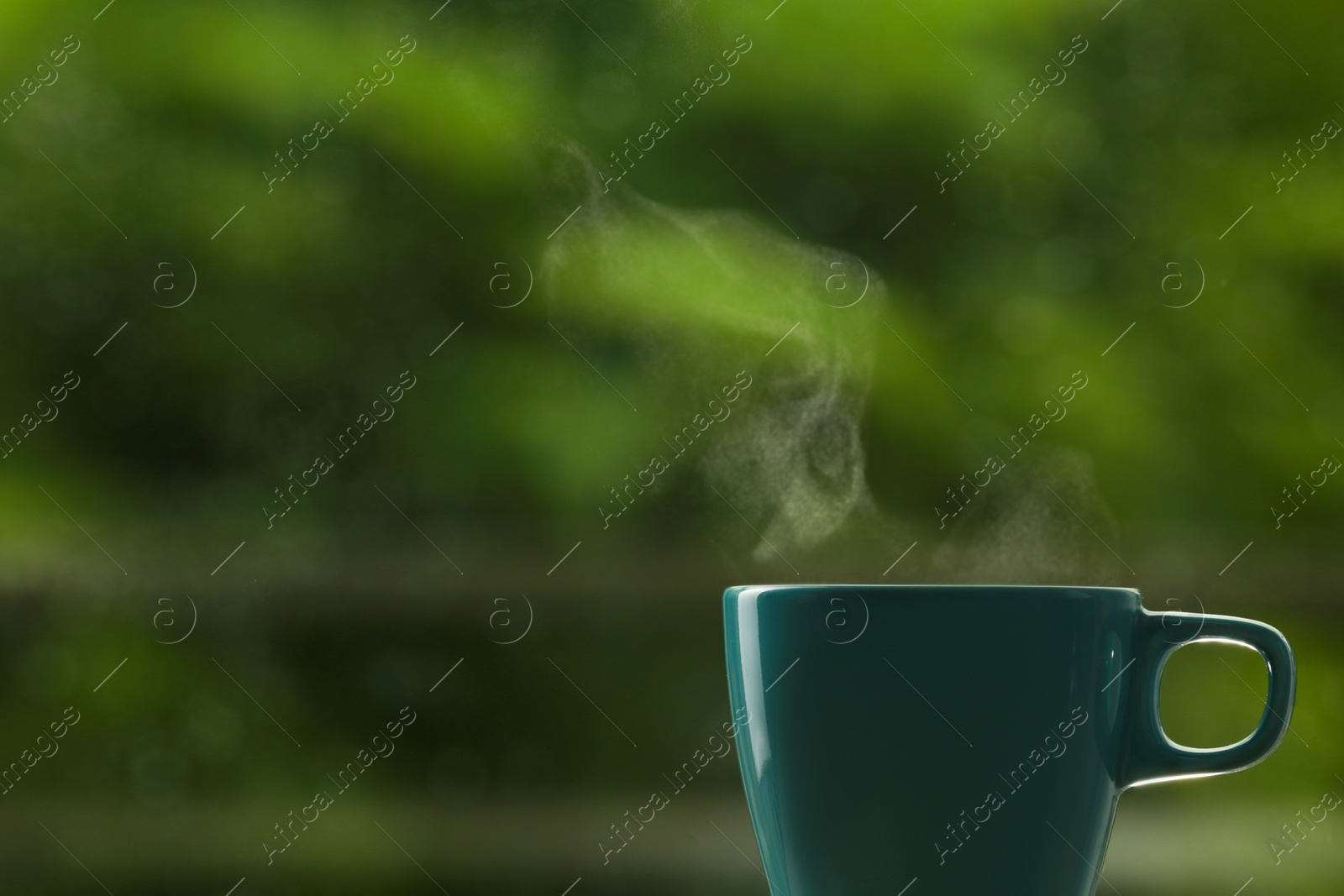 Photo of Cup of hot drink against blurred background, space for text