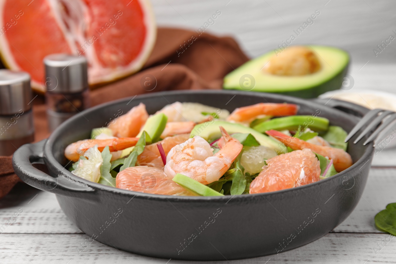 Photo of Delicious pomelo salad with shrimps served on white wooden table, closeup