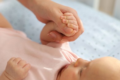 Photo of Mother with her cute little baby in crib, closeup