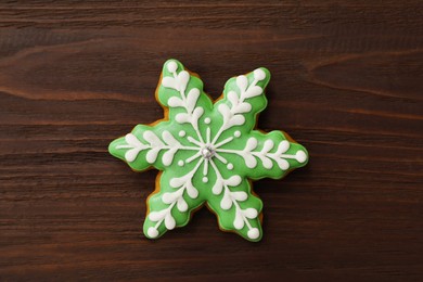 Snowflake shaped Christmas cookie on wooden table, top view