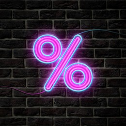 Image of Glowing neon percent sign on brick wall