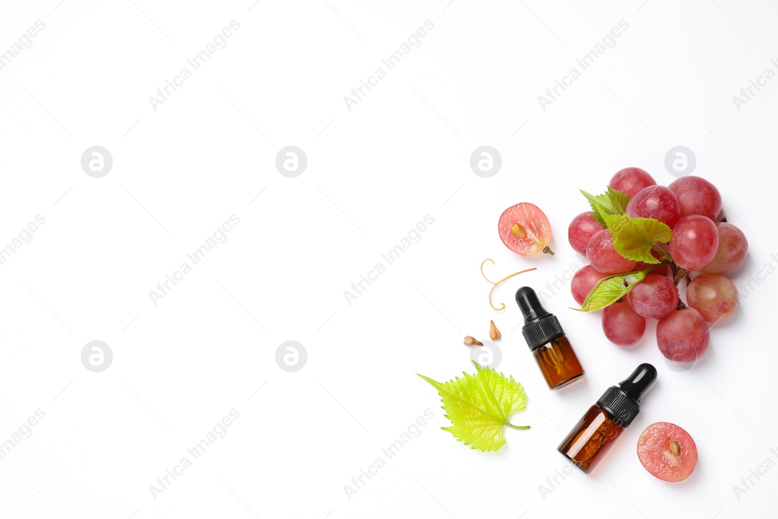 Photo of Composition with bottles of natural grape seed oil on white background, top view. Organic cosmetic