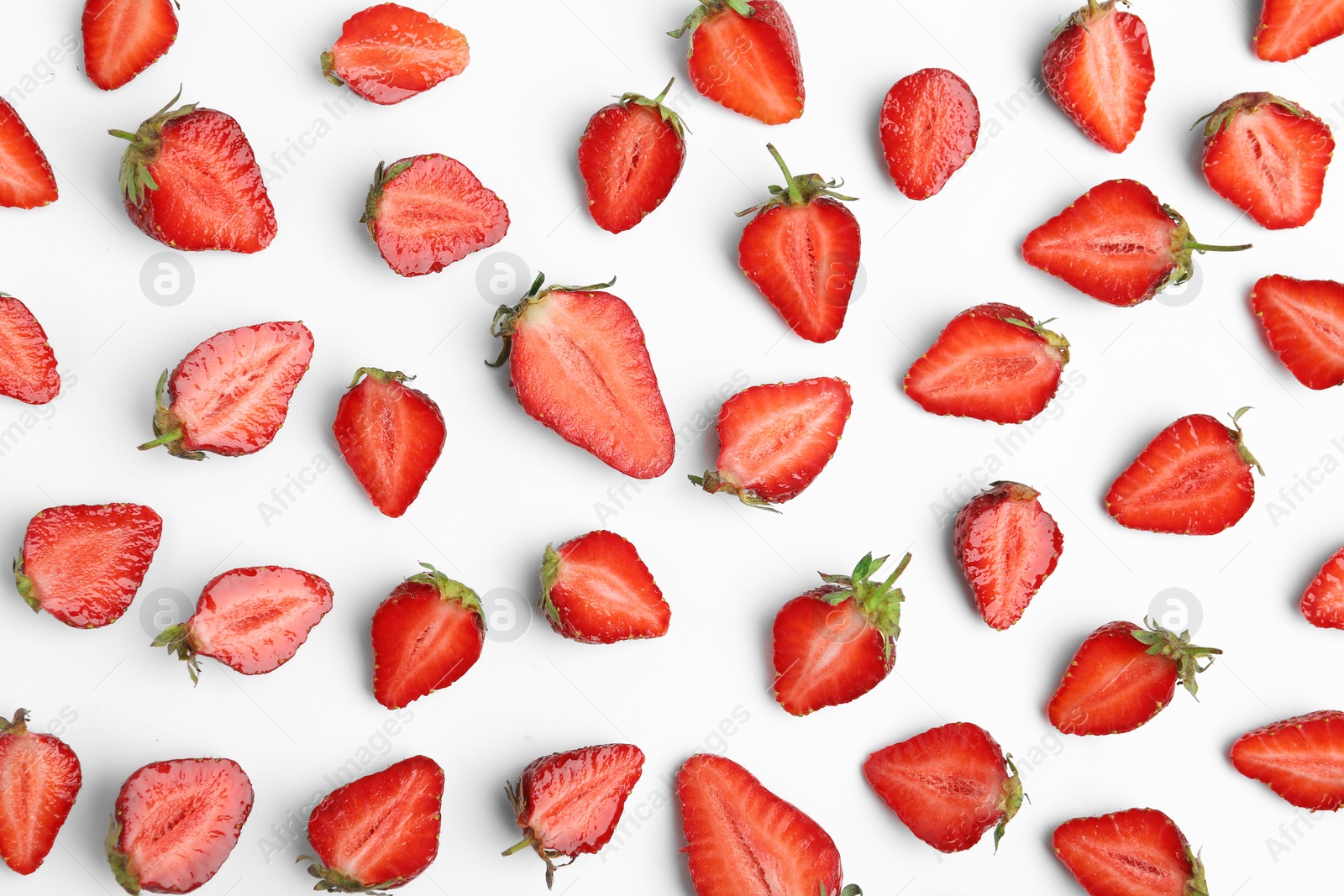 Photo of Halves of delicious ripe strawberries on white background, flat lay