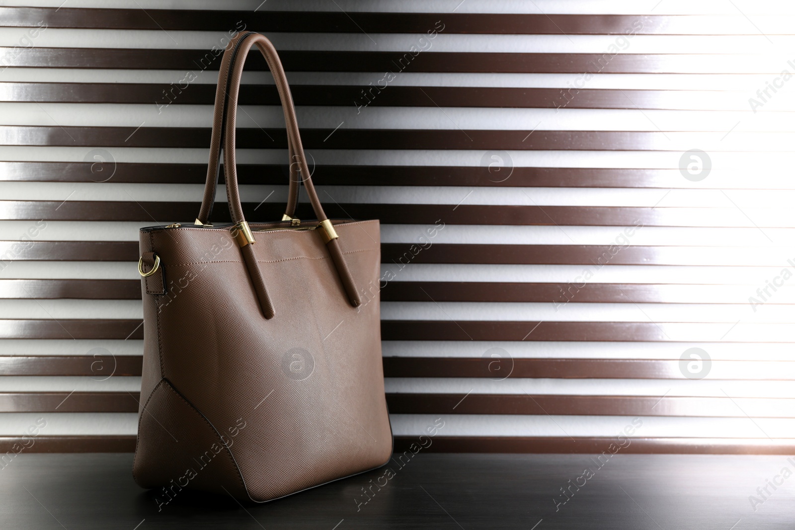 Photo of Stylish woman's bag on dark grey table. Space for text
