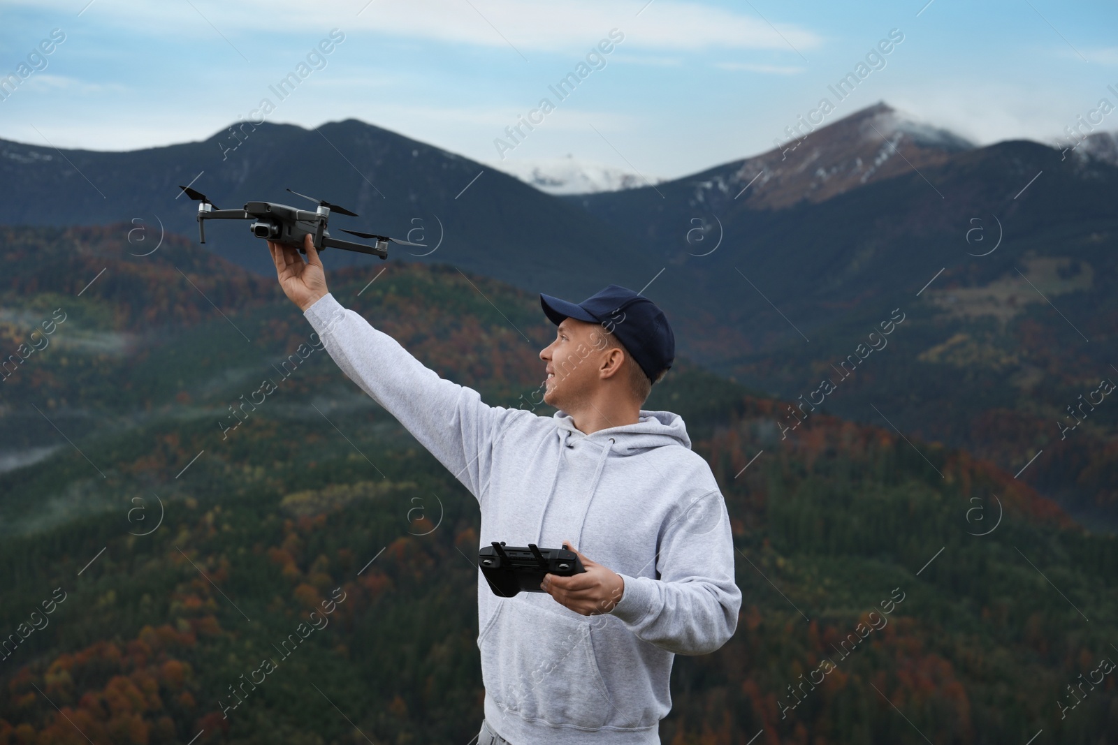 Photo of Young man with modern drone in mountains