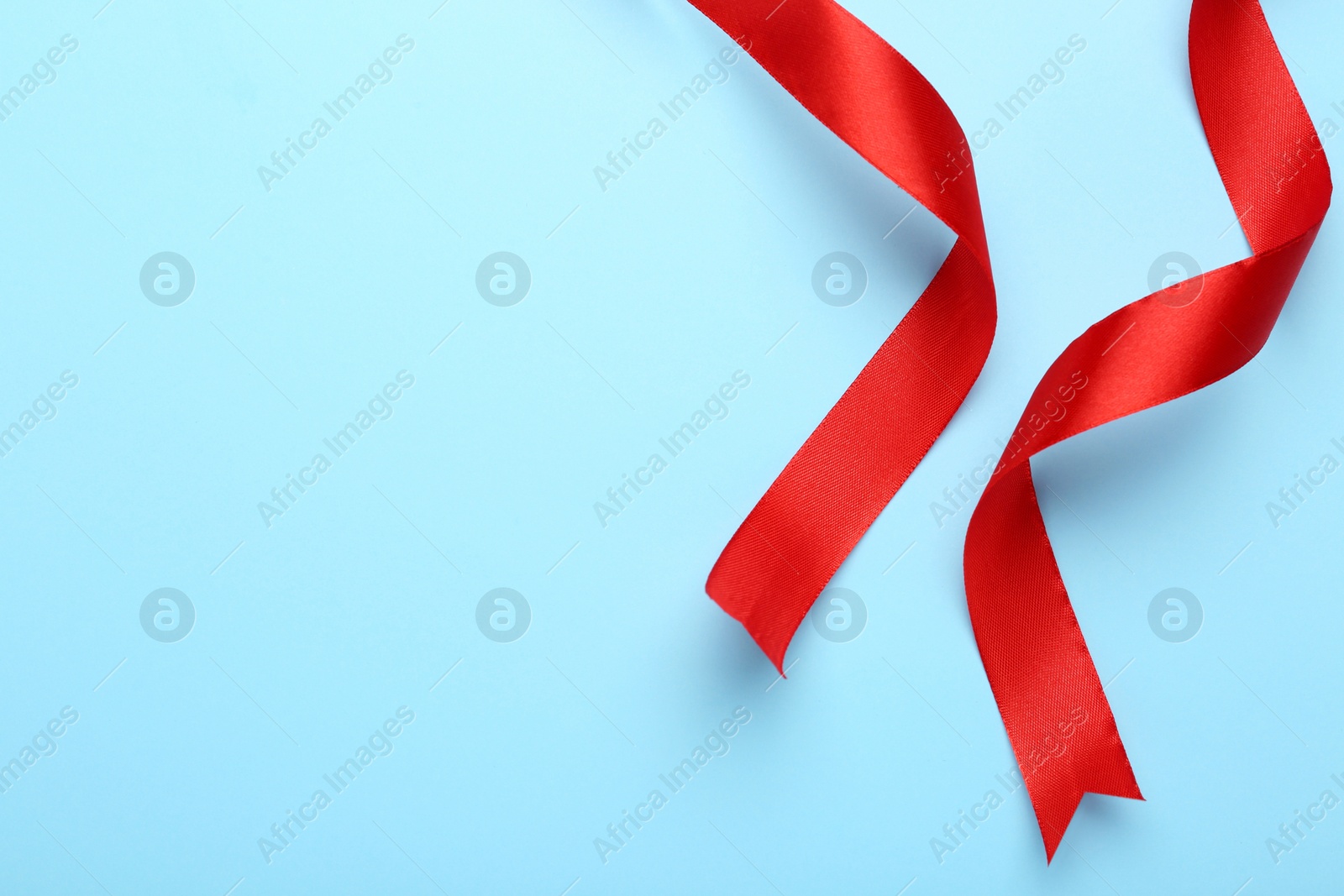 Beautiful red ribbons on light background, flat lay. Space for text Photo of Beautiful red ribbons on light background, flat lay. Space for text