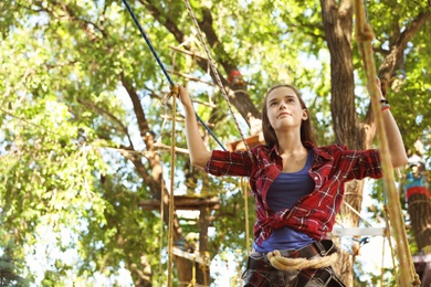Photo of Teenage girl climbing in adventure park. Summer camp