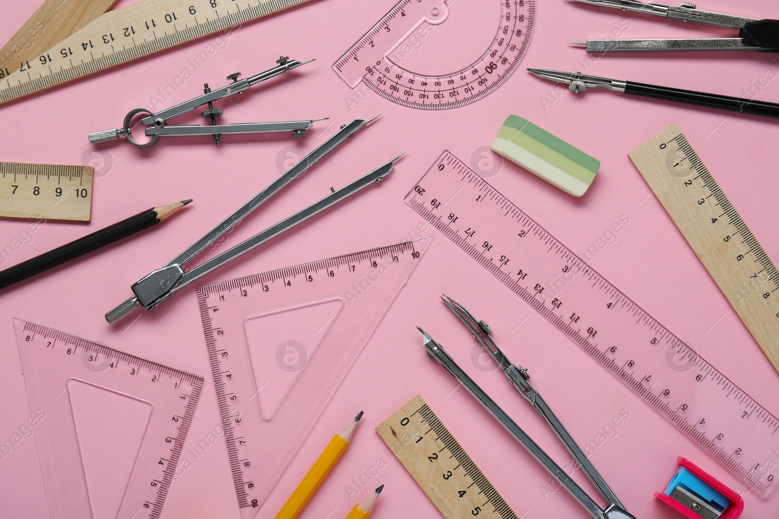 Photo of Flat lay composition with different rulers and stationery on pink background