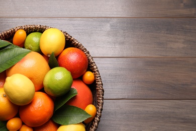 Different citrus fruits on wooden table, top view. Space for text