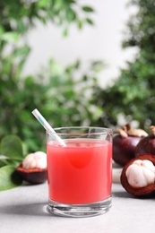 Photo of Delicious mangosteen juice in glass on light table