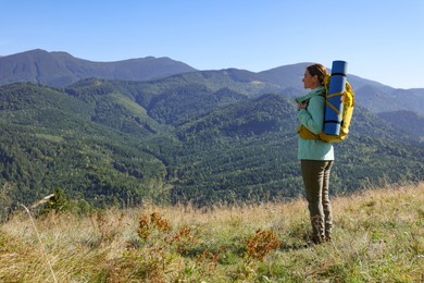 Photo of Tourist with backpack enjoying view in mountains on sunny day