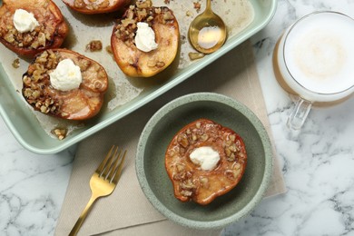 Photo of Tasty baked quinces with nuts and cream cheese served on white marble table, flat lay