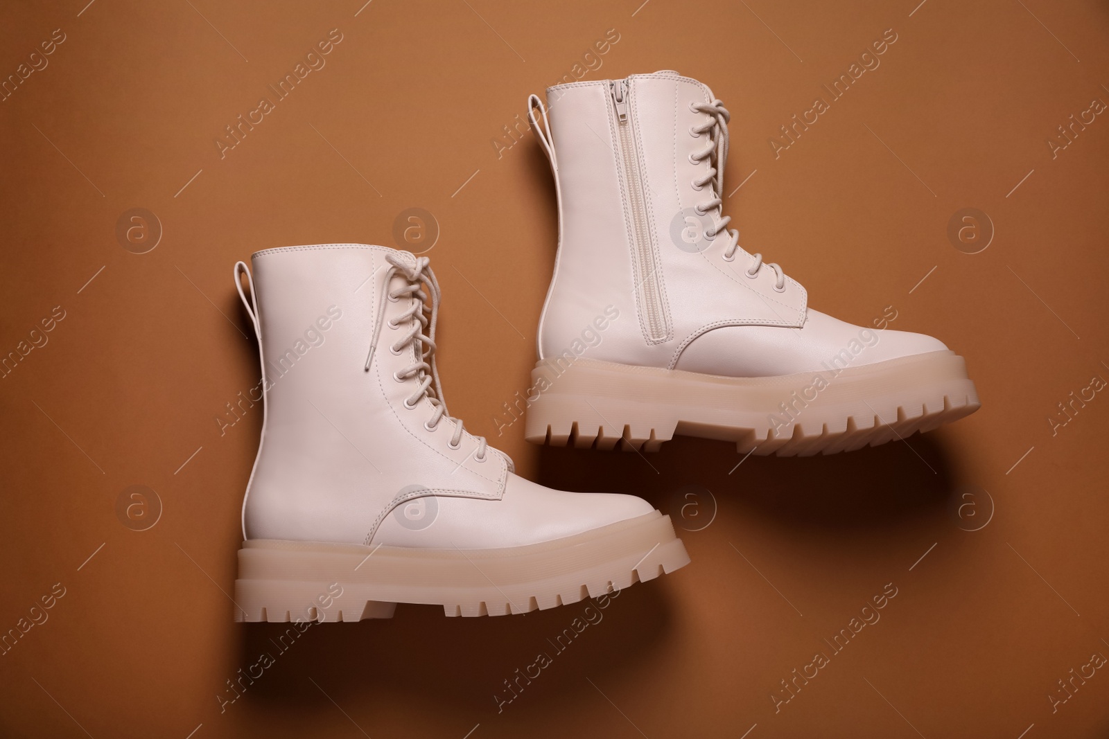 Photo of Pair of stylish leather shoes on light brown background, flat lay