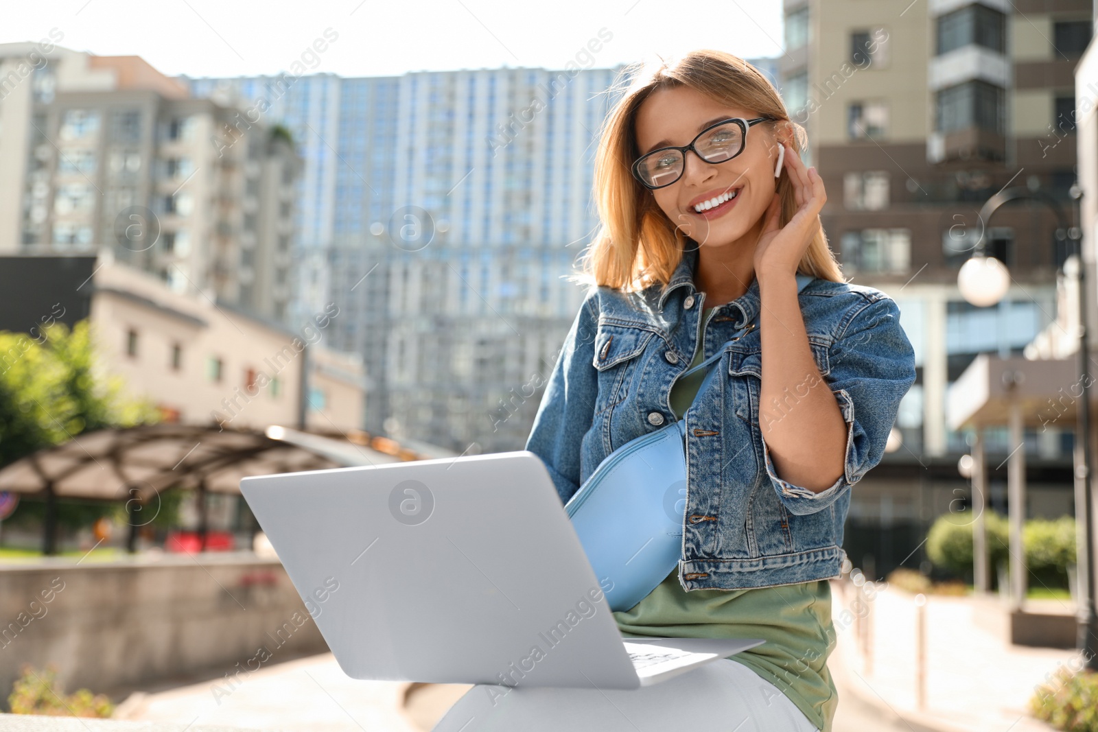 Photo of Beautiful woman using laptop in city on sunny day