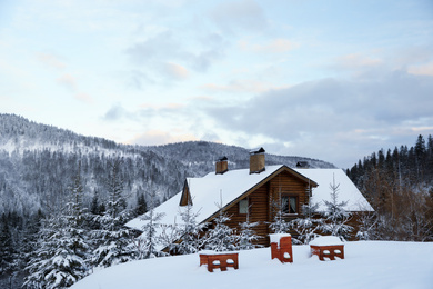 Photo of Wooden cottage near snowy forest outdoors on winter day