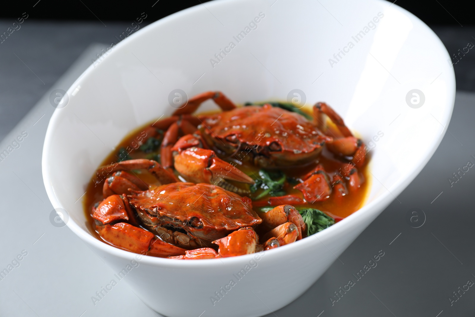 Photo of Delicious boiled crabs with sauce on table, closeup