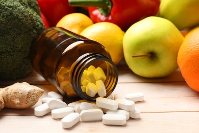 Dietary supplements. Overturned bottle with pills near food products on light wooden table