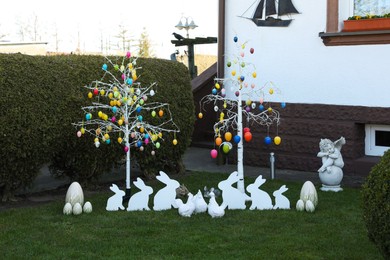 Trees with decorative eggs, chickens and bunnies at backyard. Easter celebration
