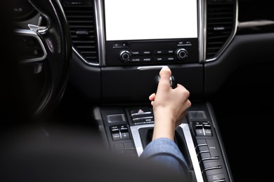 Woman using gear stick while driving her car, closeup