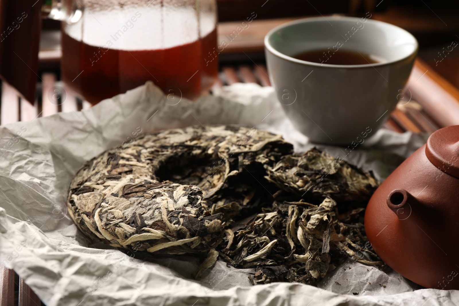 Photo of Broken disc shaped pu-erh tea on parchment paper, closeup. Traditional ceremony