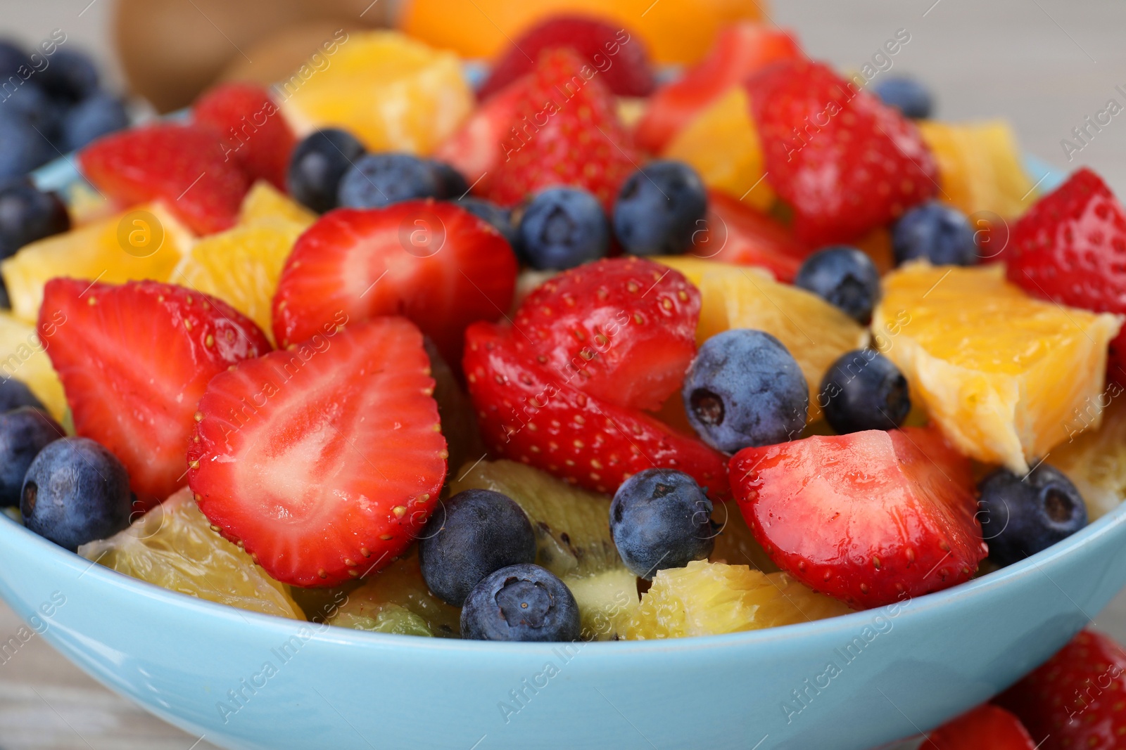 Photo of Delicious fresh fruit salad in bowl on table, closeup