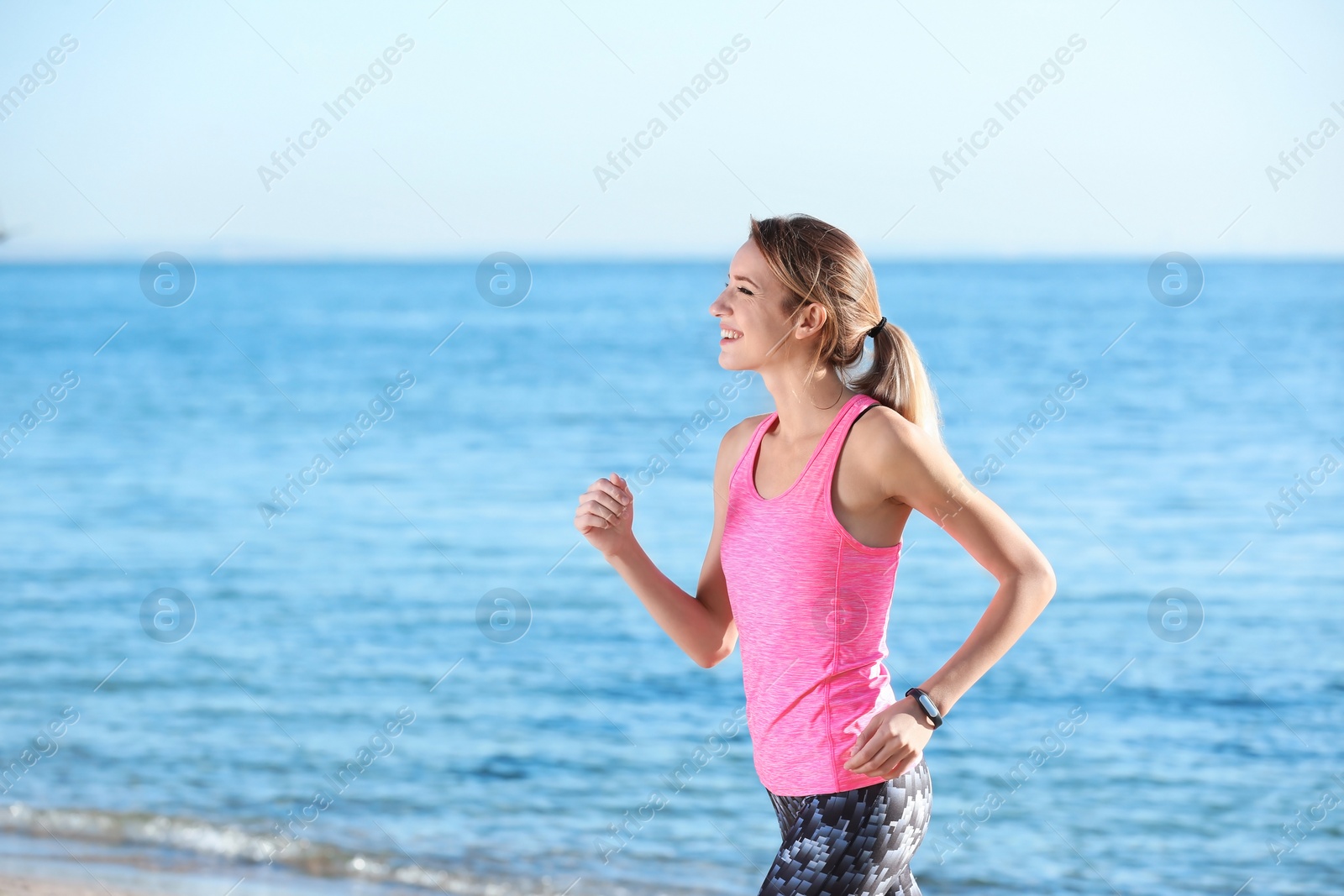 Photo of Young woman running on beach in morning