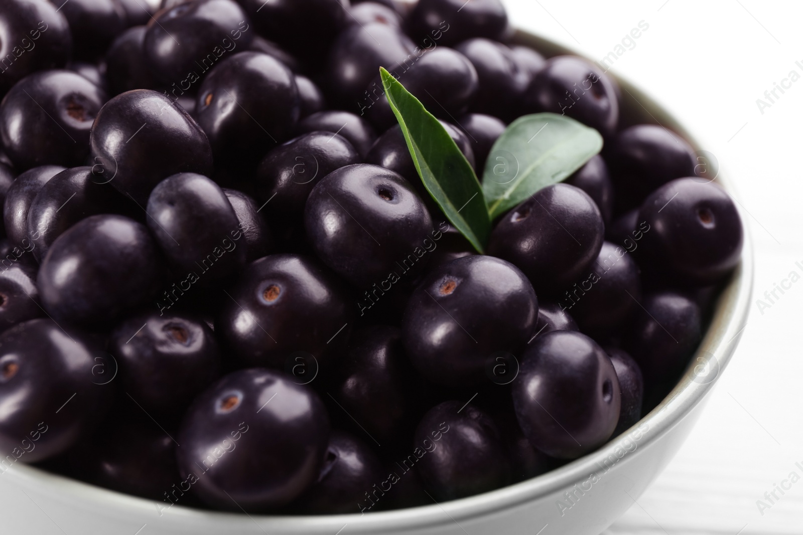 Photo of Tasty acai berries in bowl on table, closeup