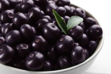 Tasty acai berries in bowl on table, closeup