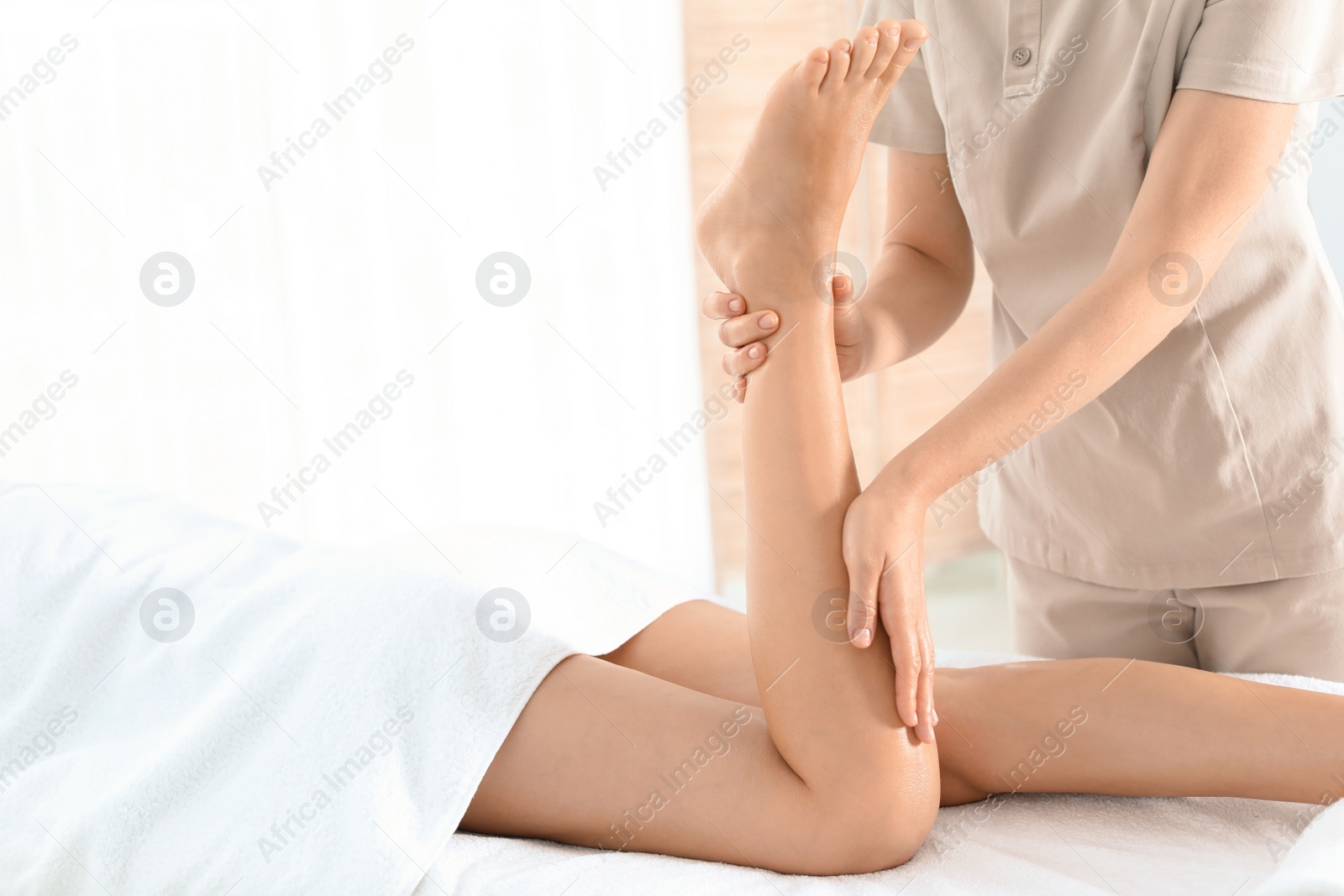 Photo of Woman receiving leg massage in wellness center