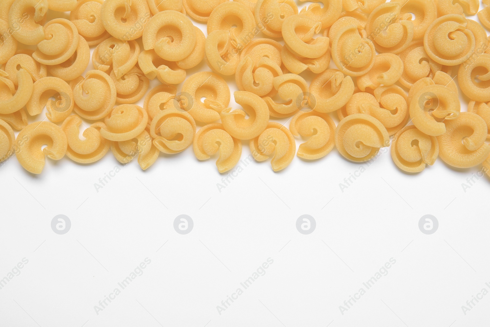 Photo of Raw dischi volanti pasta on white background, top view. Space for text