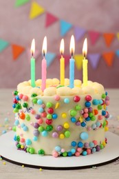 Photo of Cute bento cake with tasty cream and burning candles on white wooden table