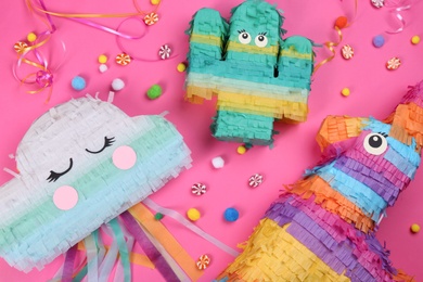 Different bright pinatas on pink background, flat lay