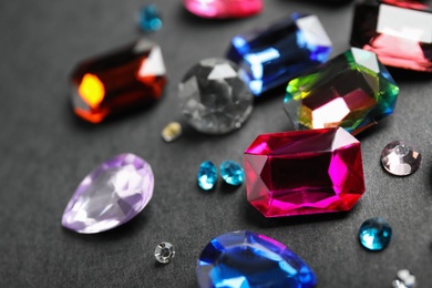 Different beautiful gemstones on black background, closeup
