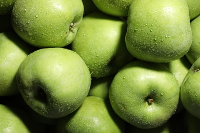 Photo of Fresh green apples with water drops as background, top view